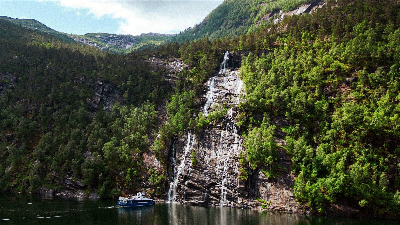 Bergen fjord cruise boat at a waterfall near Mostraumen
